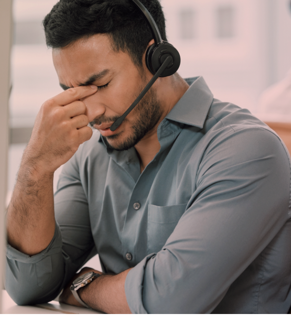 Sales professional experiencing stress and sales reluctance at desk